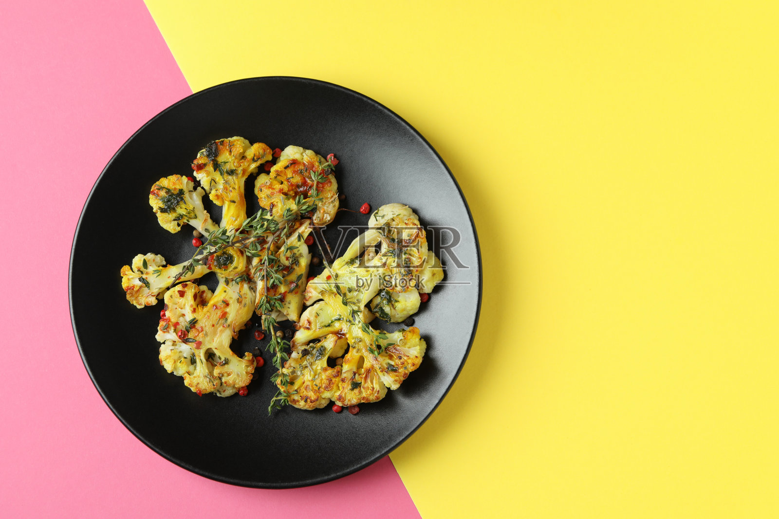 盘子与烤花椰菜在两个色调的背景照片摄影图片