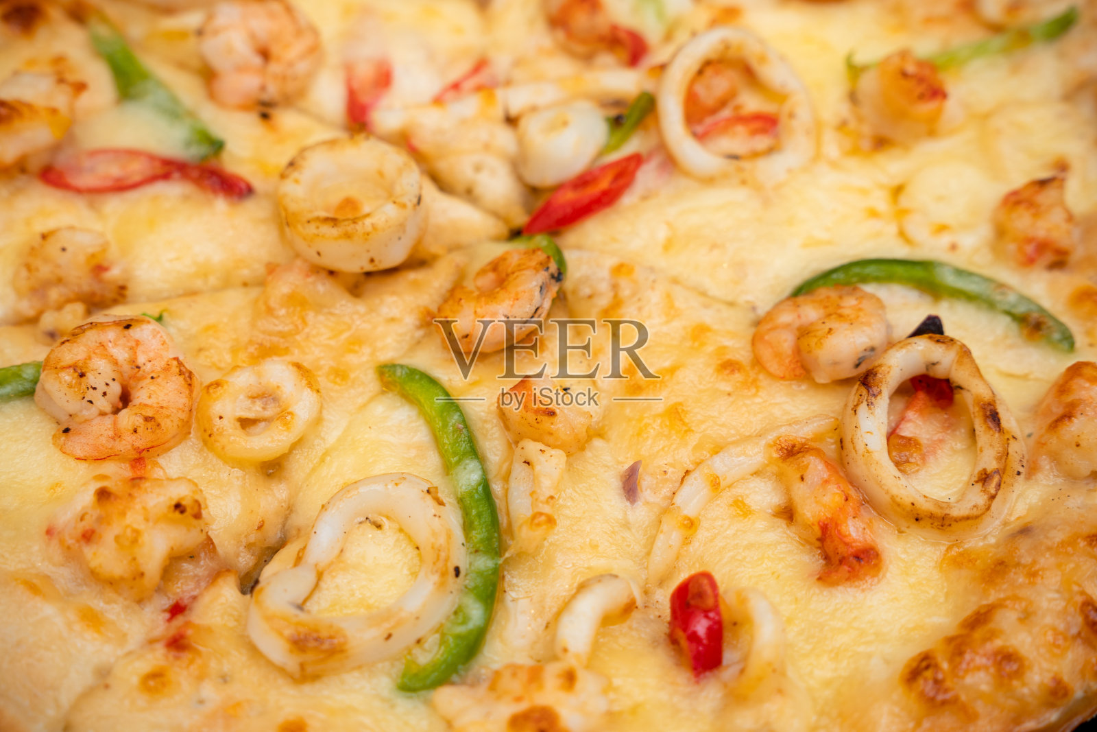 披萨配虾、鲑鱼、鱿鱼和橄榄。俯视图照片摄影图片