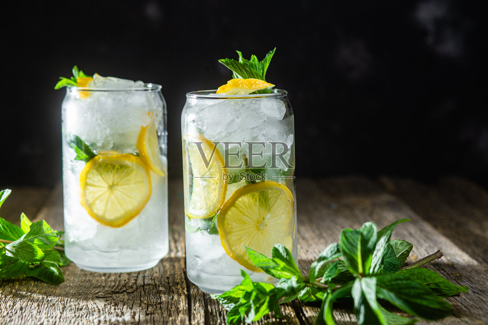 冷柠檬汁，薄荷，柠檬和冰在黑暗的背景照片摄影图片