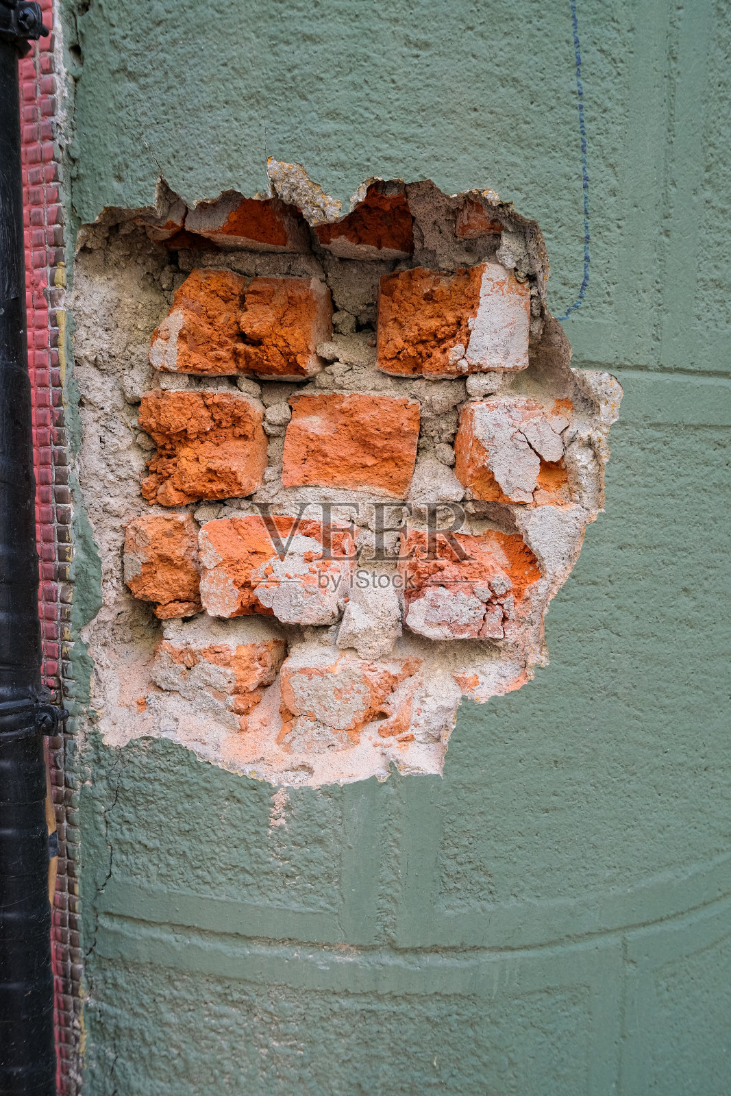 损坏的红砖墙。墙上有个洞照片摄影图片