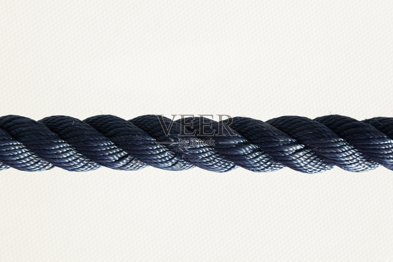 白色背景中均匀拉伸的黑色编织绳照片摄影图片