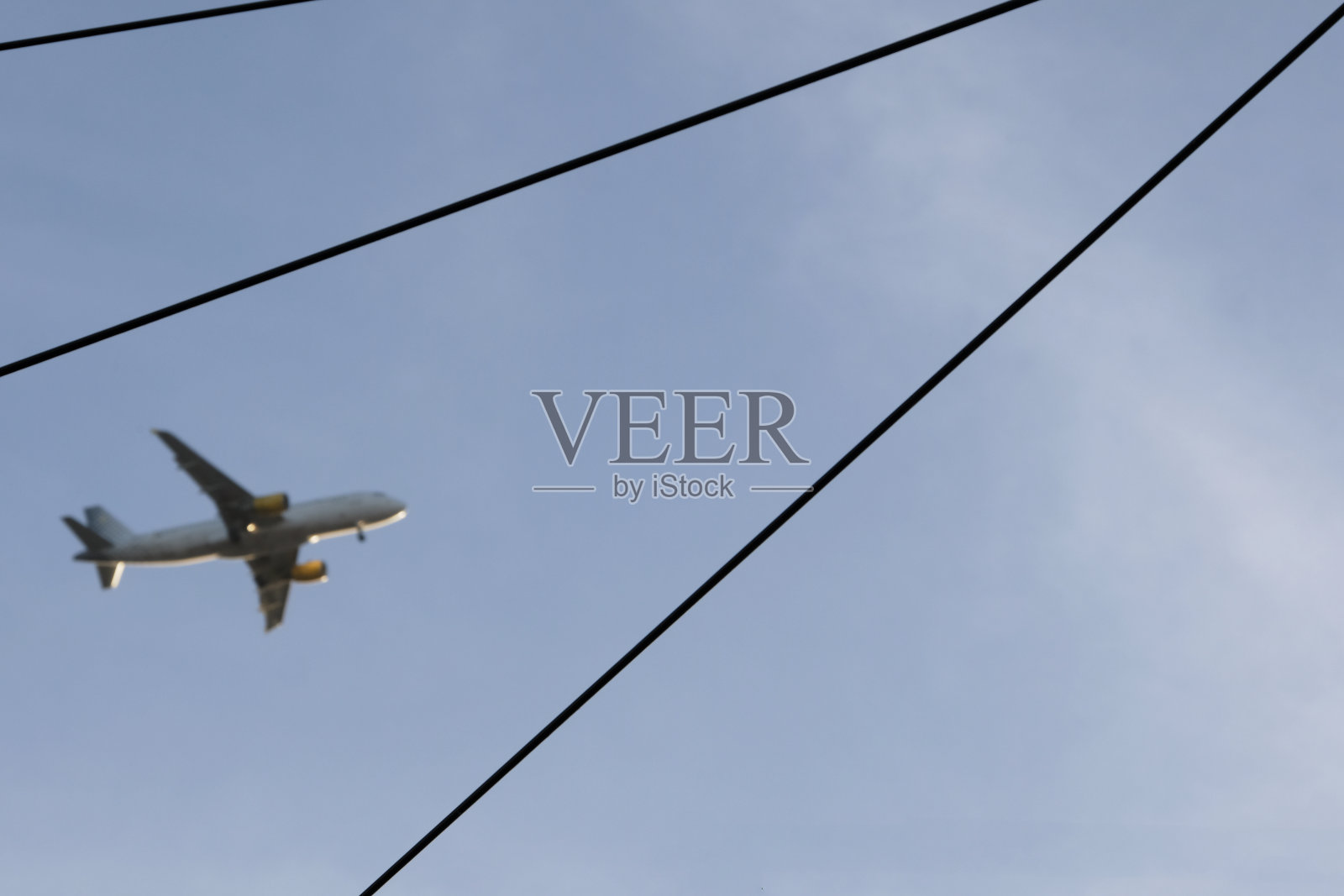 在晴朗的天空下，正在接近的飞机照片摄影图片