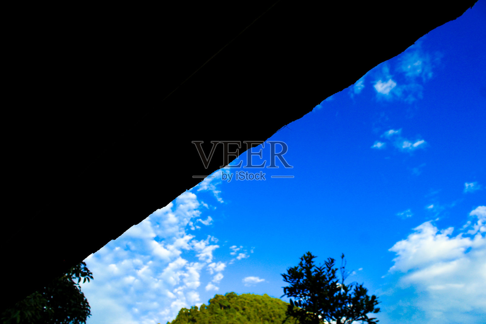 低角度的一个宁静的自然场景与黑色阴影三角形框架，蓝天，和云照片摄影图片