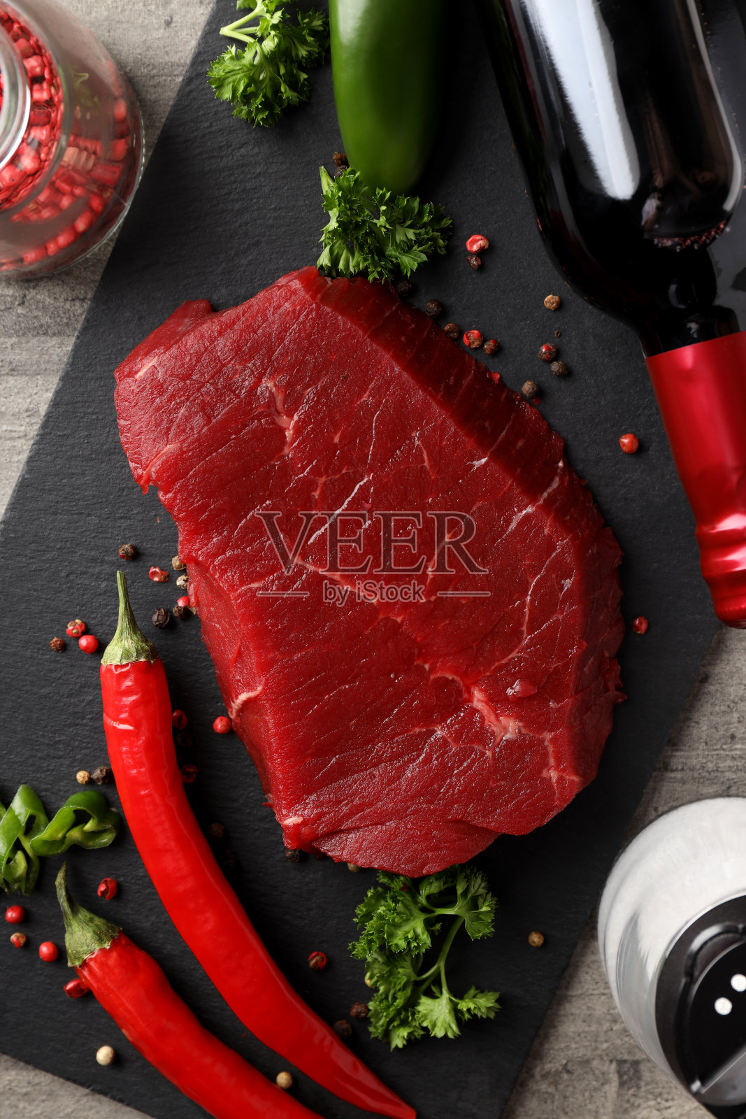 在灰色纹理背景上用生牛排烹饪的概念照片摄影图片