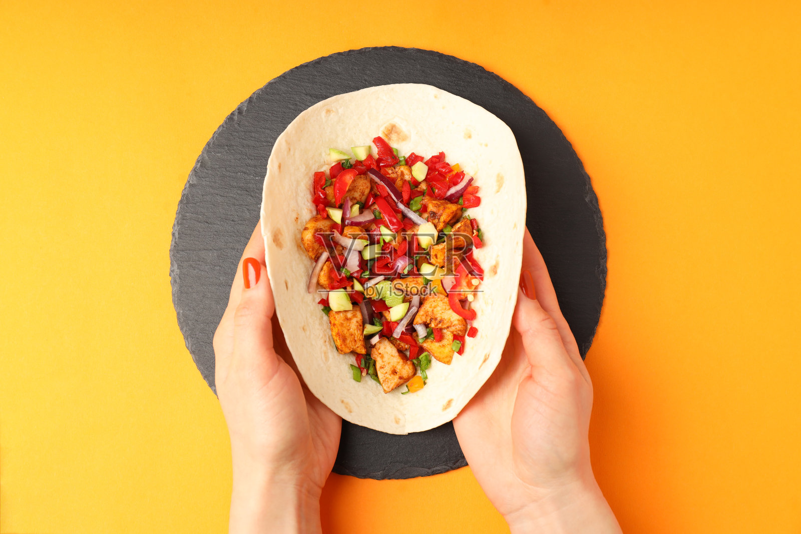 船上有美味的墨西哥卷饼，橙色背景照片摄影图片