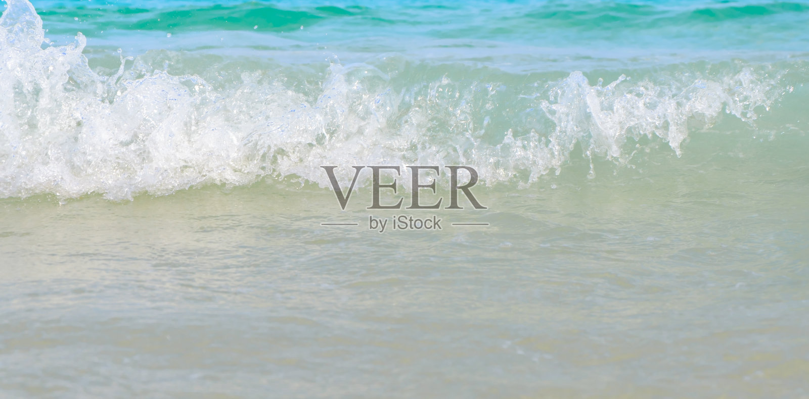 海浪打在沙滩上，海是美丽的，晶莹碧绿。近距离照片摄影图片