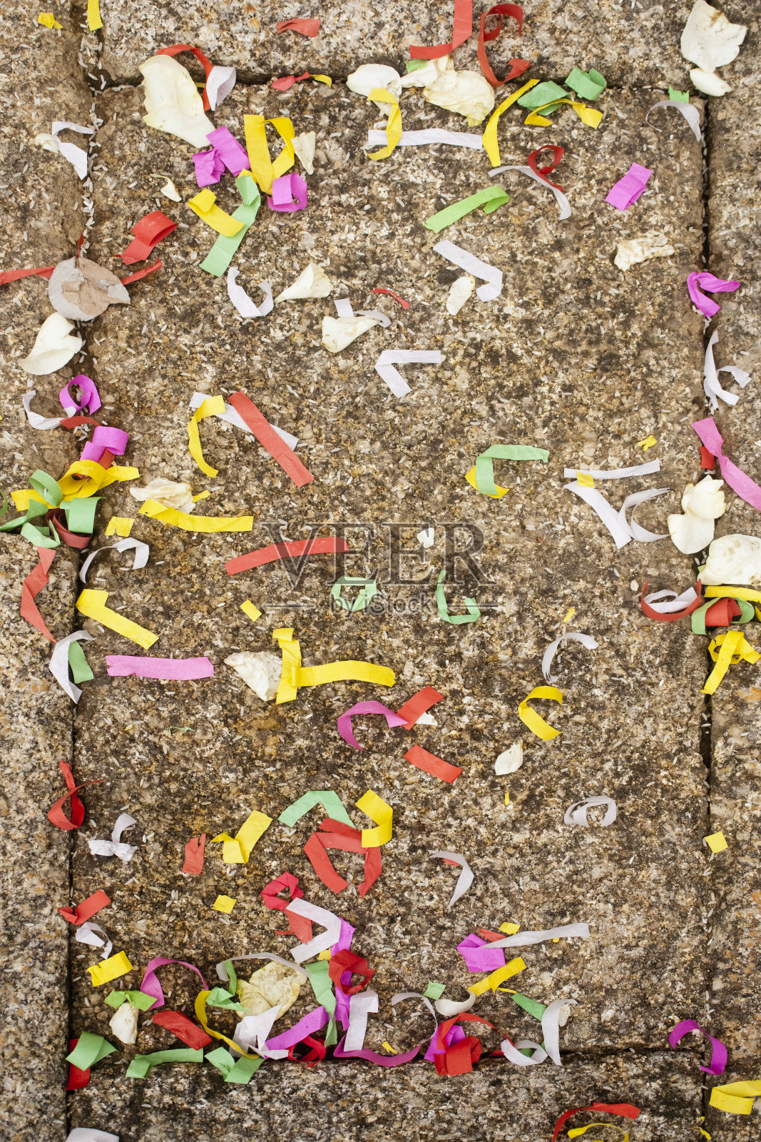 婚礼结束后，古老的石头地板上铺着花瓣和五彩纸屑。照片摄影图片