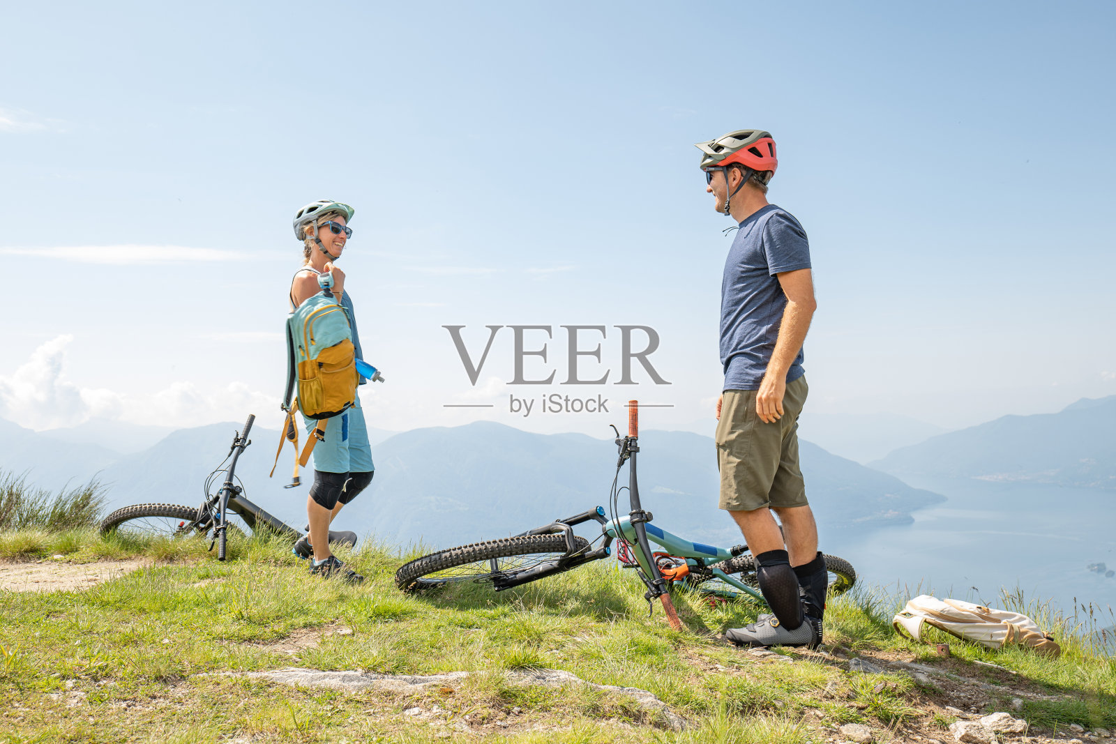 一对骑山地车的夫妇在山顶休息，看风景照片摄影图片