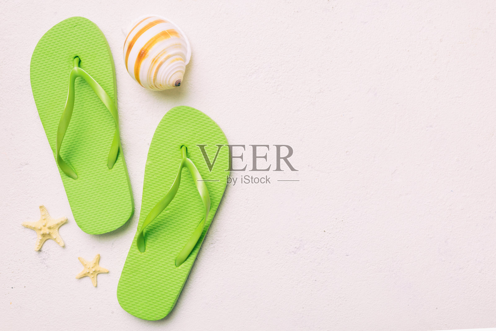 在彩色背景上用人字拖和贝壳平铺构图。文本顶视图的空间照片摄影图片