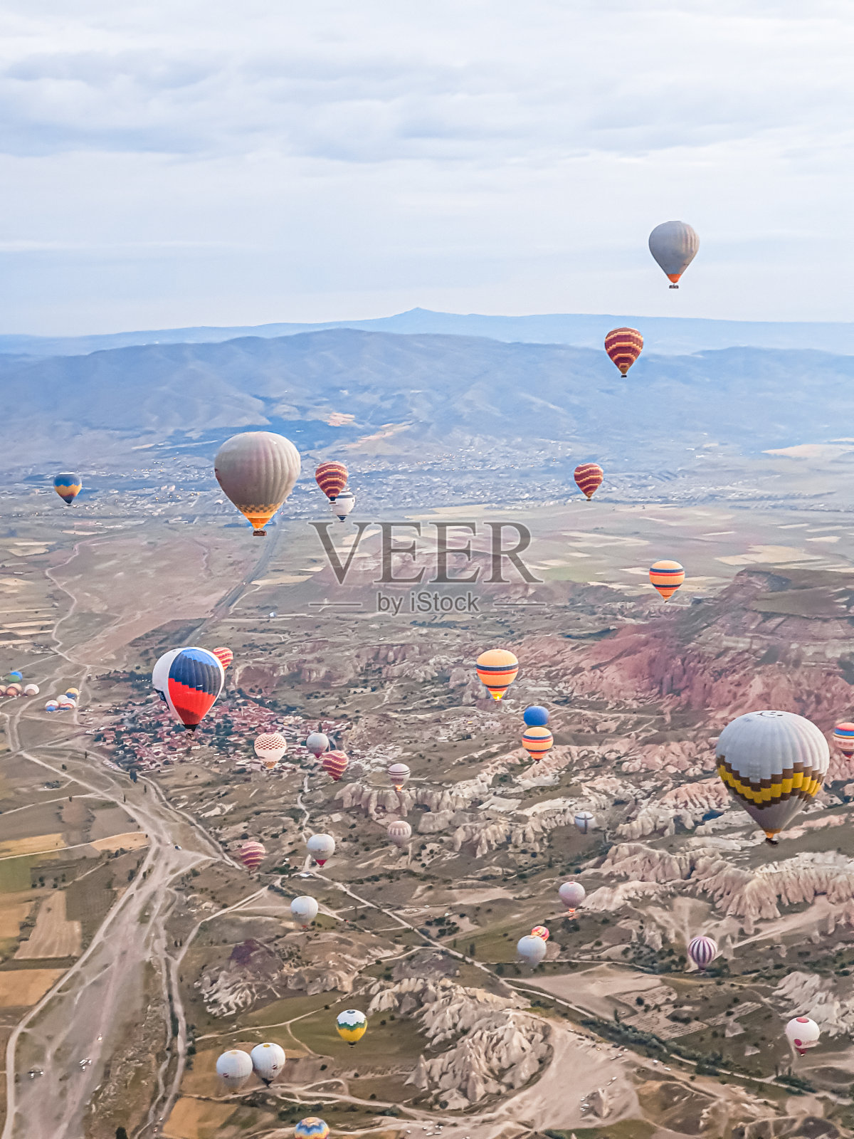清晨时分，在卡帕多西亚山区，将许多美丽的彩色气球发射到空中。用燃烧器的热空气填充气球，准备篮子。观光、航班以上供游客乘坐照片摄影图片