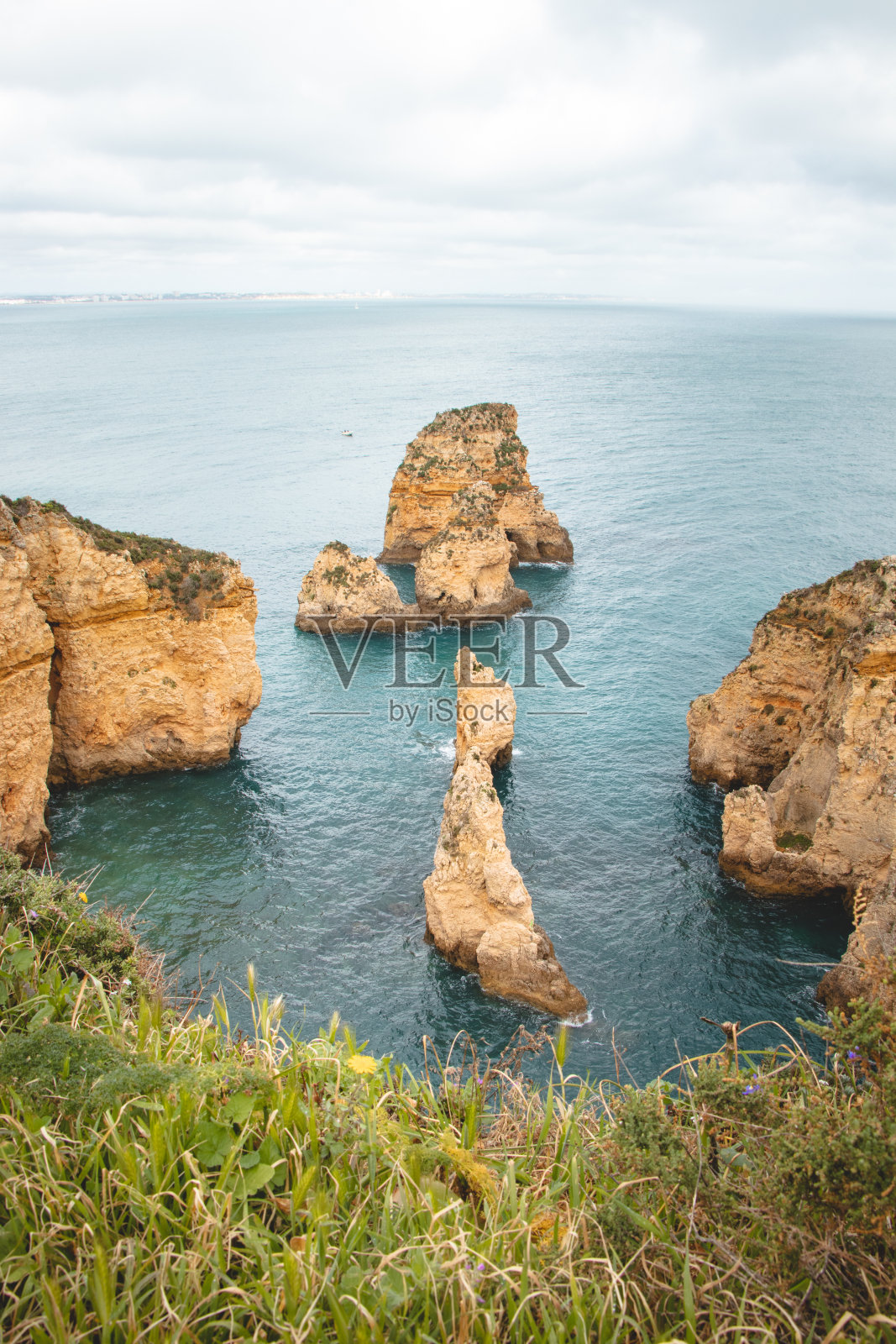 蓬塔达皮达德是著名的旅游目的地，位于葡萄牙阿尔加维地区拉各斯半岛南部。午后的金色悬崖海角照片摄影图片