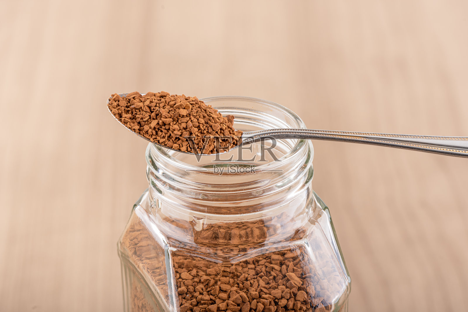 把速溶咖啡放在一个打开的玻璃咖啡罐里。照片摄影图片