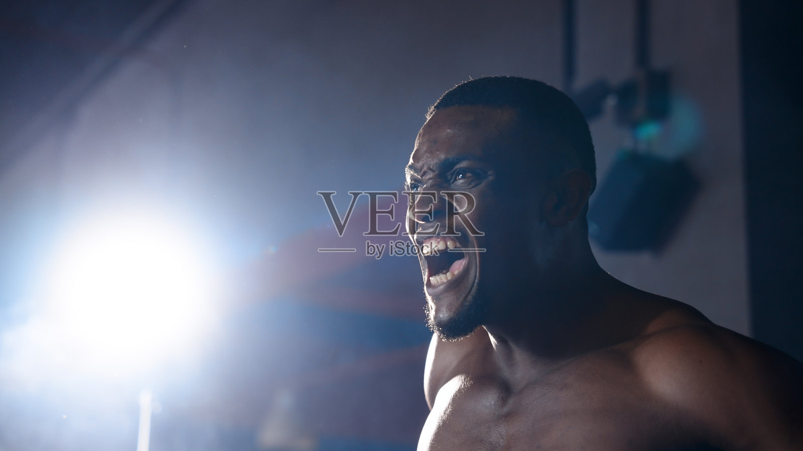 非洲拳击手戴着头盔和手套走向拳击台。白种人左拳右拳交替打。眼睛决心要在拳击场上打败对手。照片摄影图片