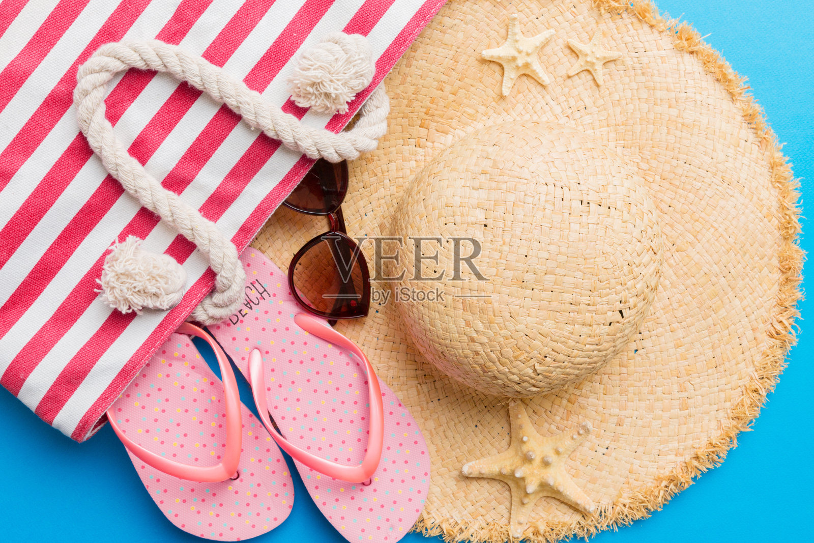 沙滩配件平铺上视图彩色背景夏季旅游概念。袋子里有海星和海贝。俯视图照片摄影图片