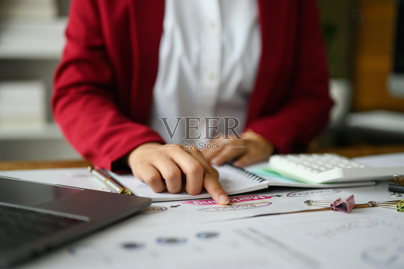 女性分析师使用计算器查看市场研究结果或统计数据的近景。照片摄影图片