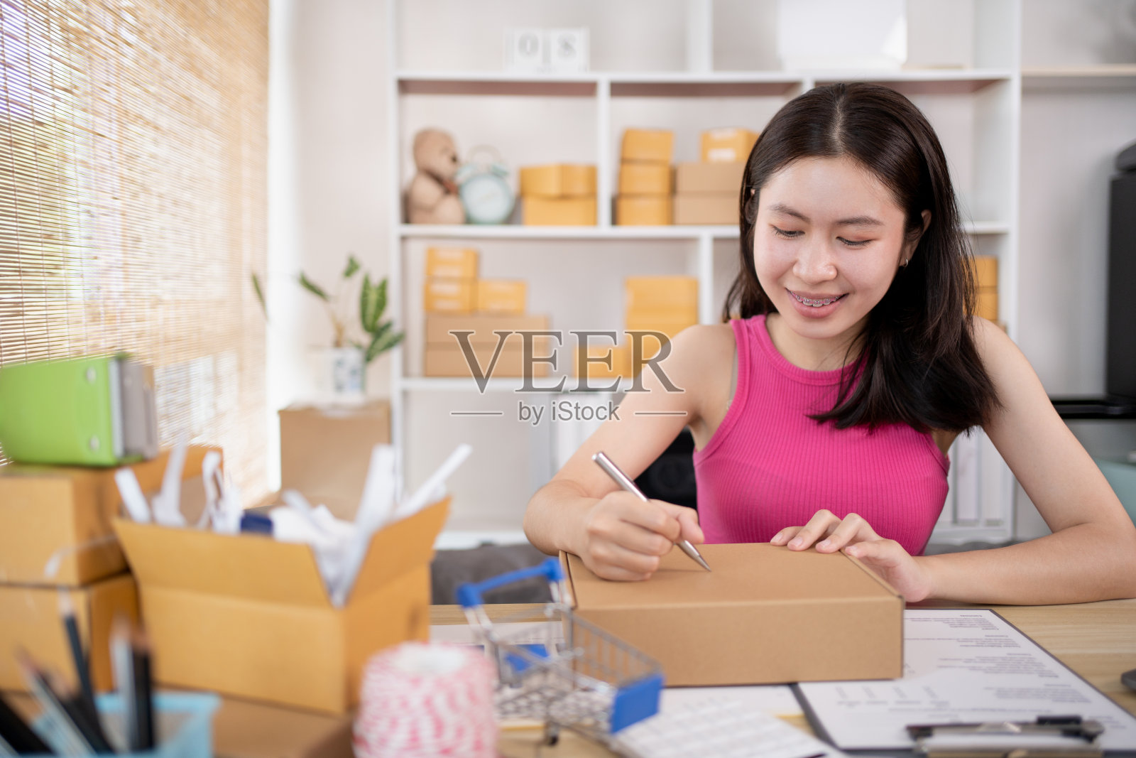 女人正在笔记本上记下顾客的详细信息和地址照片摄影图片