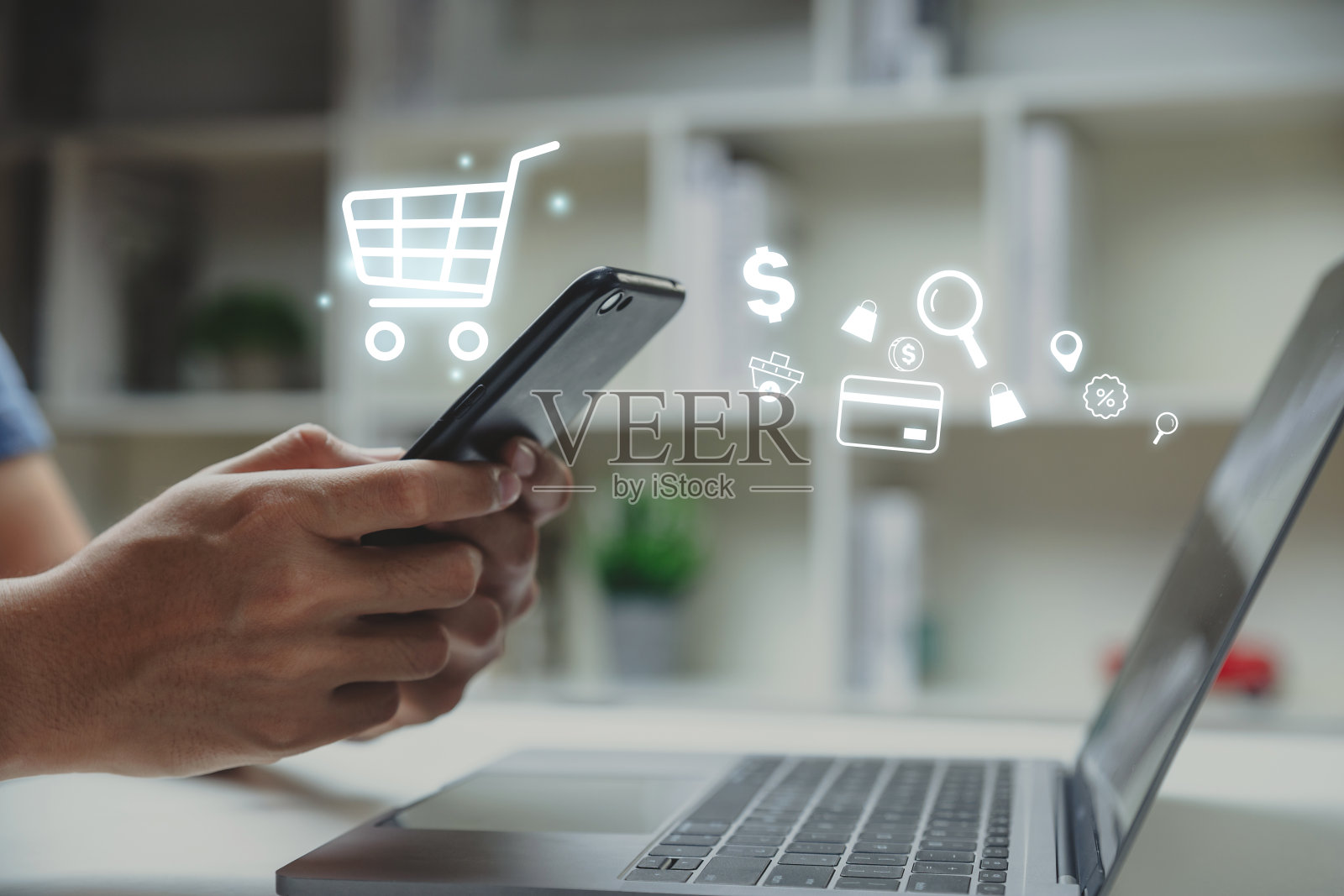 年轻人使用带有购物车图标的智能手机。照片摄影图片