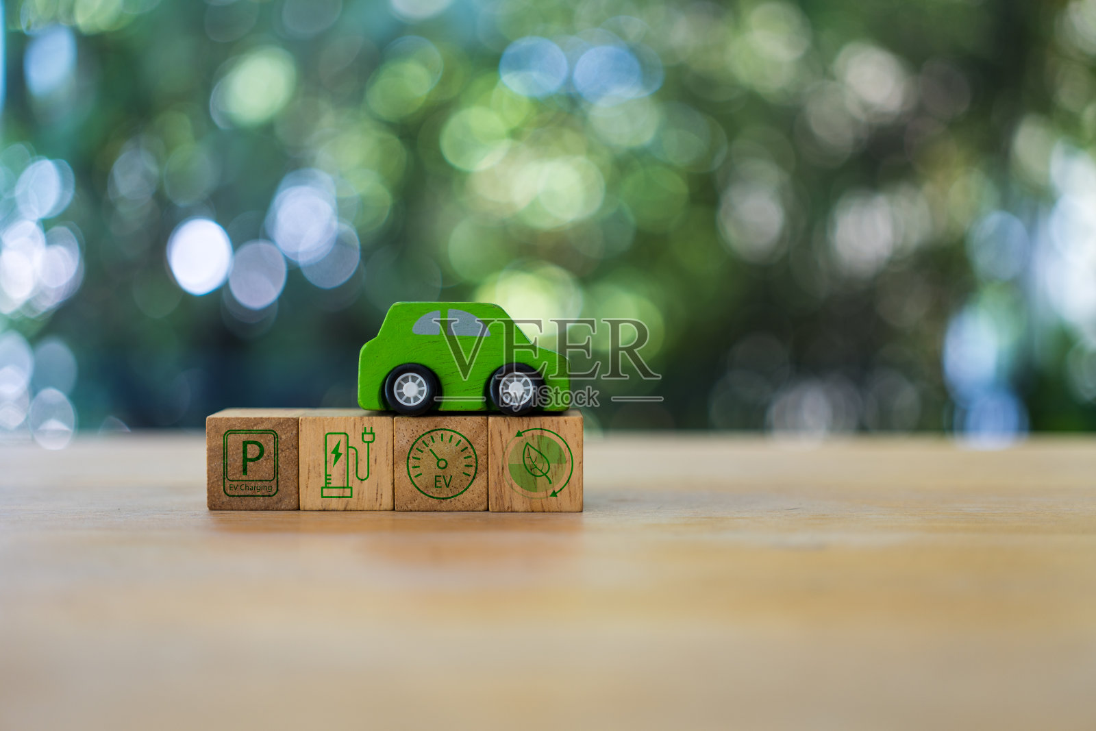 绿色木质汽车放置在木质立方体块图标的汽车EV。照片摄影图片