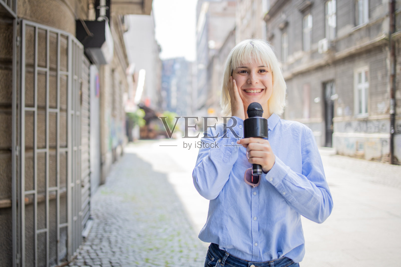 年轻的电视记者正在现场直播照片摄影图片