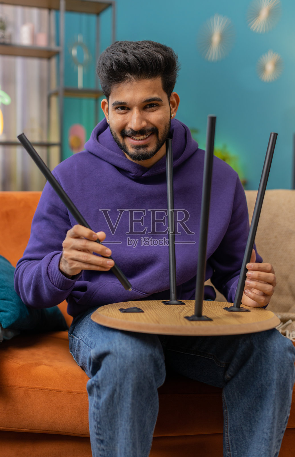 印度男子在家里的公寓组装完家具，成功地把桌子收起来修理修理照片摄影图片