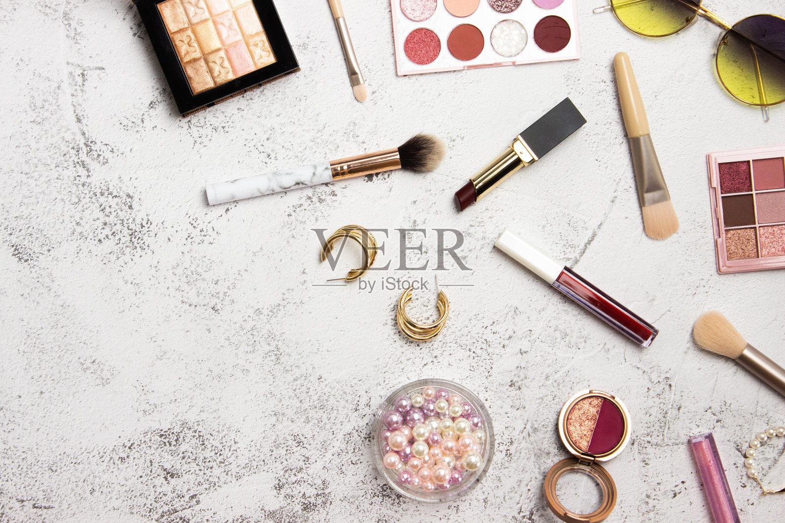 女人的饰品和化妆用口红，太阳镜，和灰色背景上的刷子。照片摄影图片