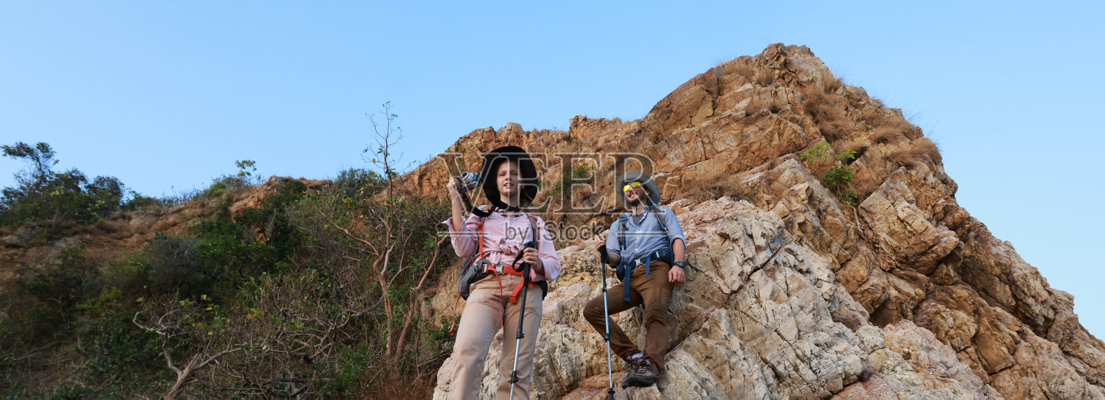 徒步队伍一边手拉手互相帮助，一边爬上岩石山上的探险旅行理念照片摄影图片