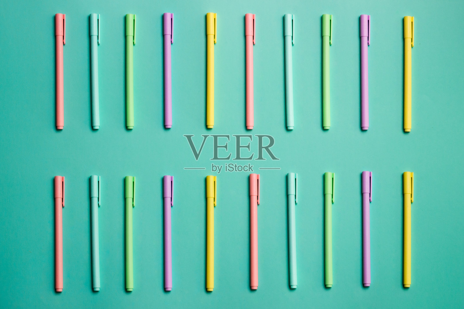 彩色铅笔在绿色背景上的特写。照片摄影图片