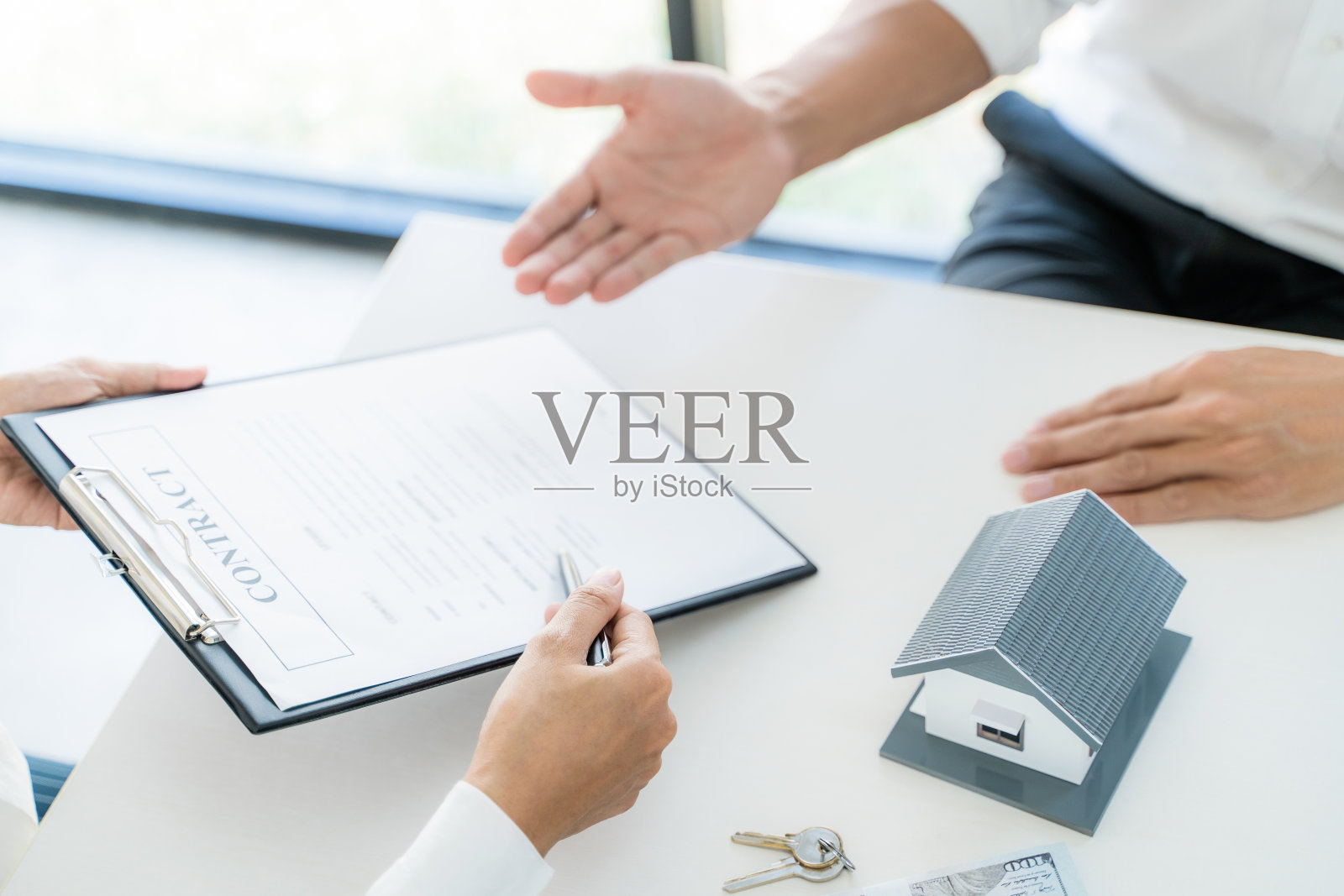 住房贷款insurance.Â
房地产经纪人与clientÂ Â签订合同保险协议文件。商务会议概念照片摄影图片