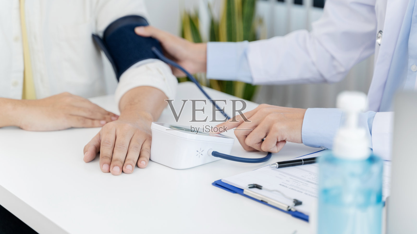 医生在医务室给病人量血压。来访医师概念照片摄影图片