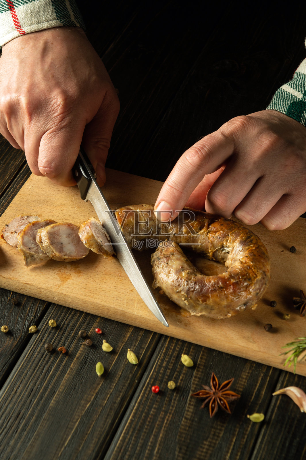 厨师的手用刀在切菜板上切烤猪肉香肠，为餐厅的美味午餐。缅甸东北国菜照片摄影图片