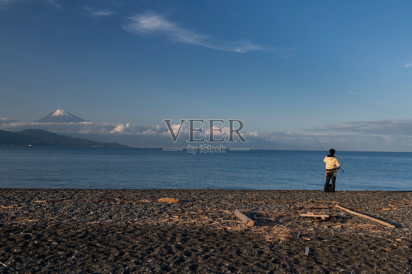 日本男子在黑美穗海滩与富士山，清水钓鱼照片摄影图片