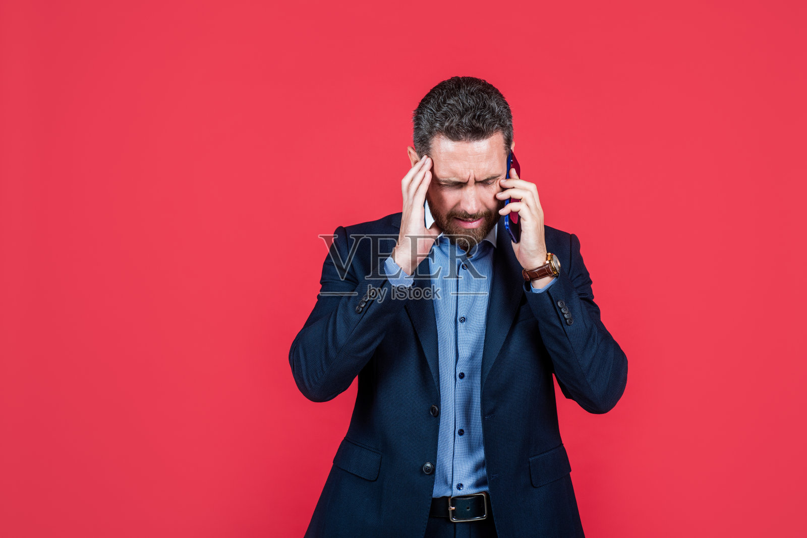 不开心的男人穿着时髦的职业装在电话里聊天照片摄影图片