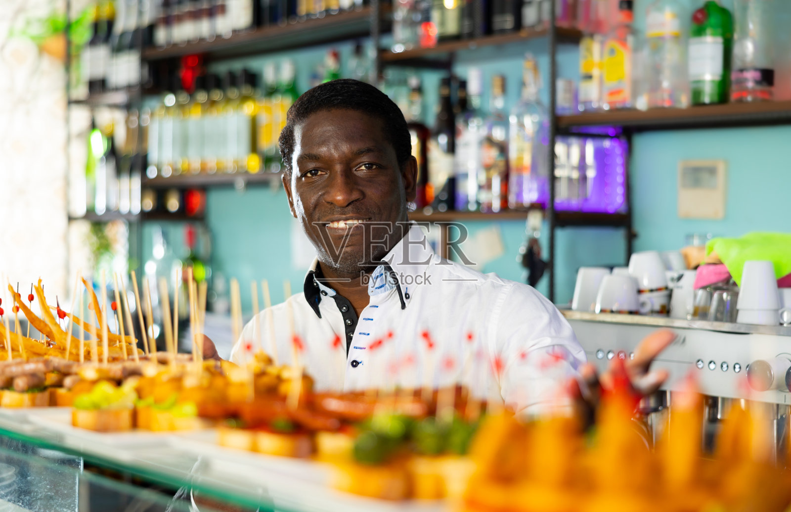 吧台后面的酒保，给客人上新鲜的三明治照片摄影图片