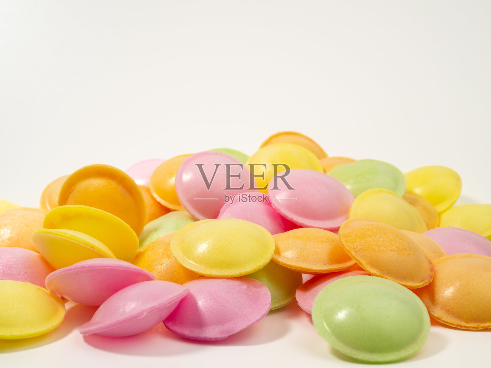 白色背景上不同颜色的不明飞行物形状的糖果。照片摄影图片