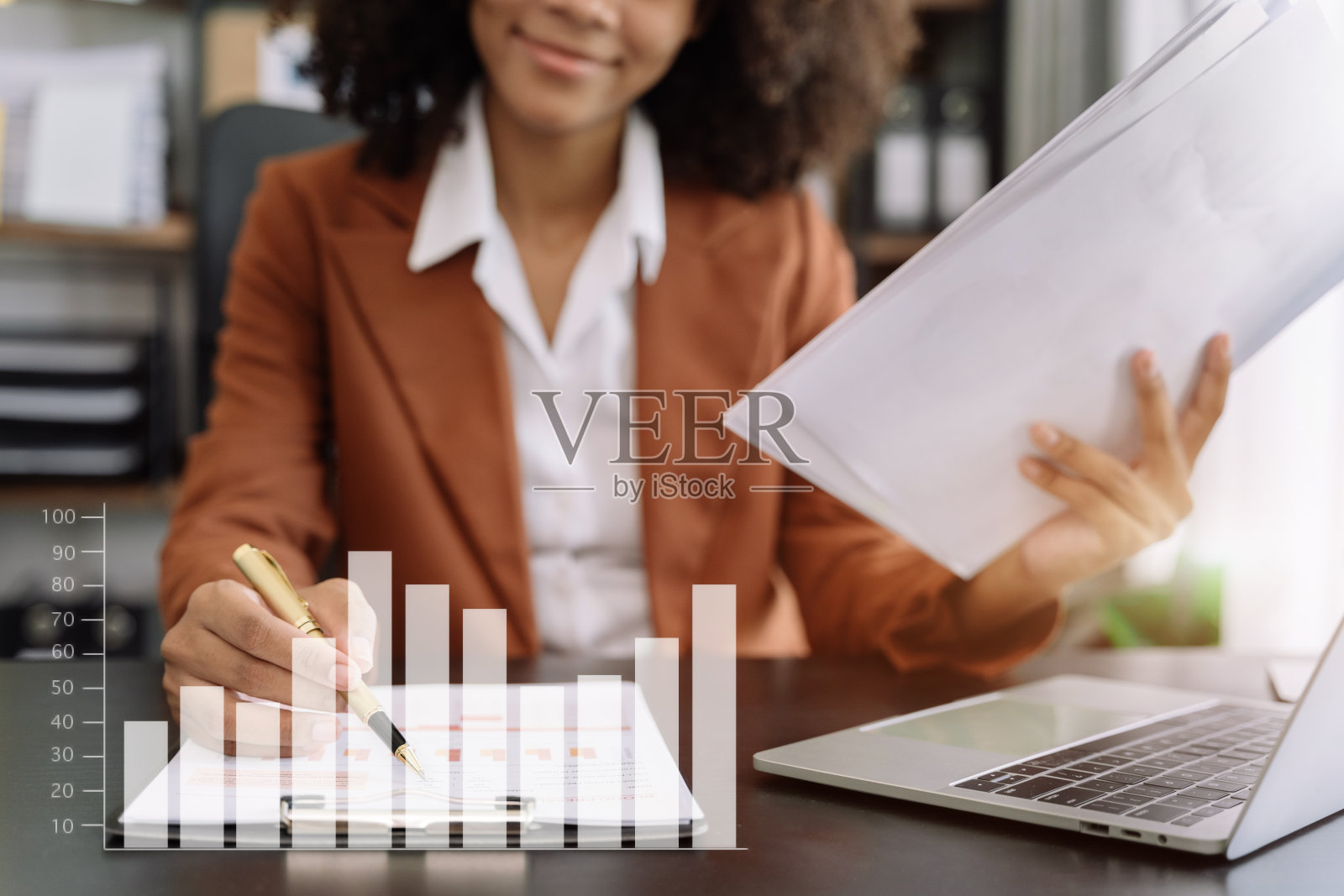 商务文件在办公桌上与笔记本电脑和智能手机和图表业务图和妇女在家庭办公室工作。照片摄影图片