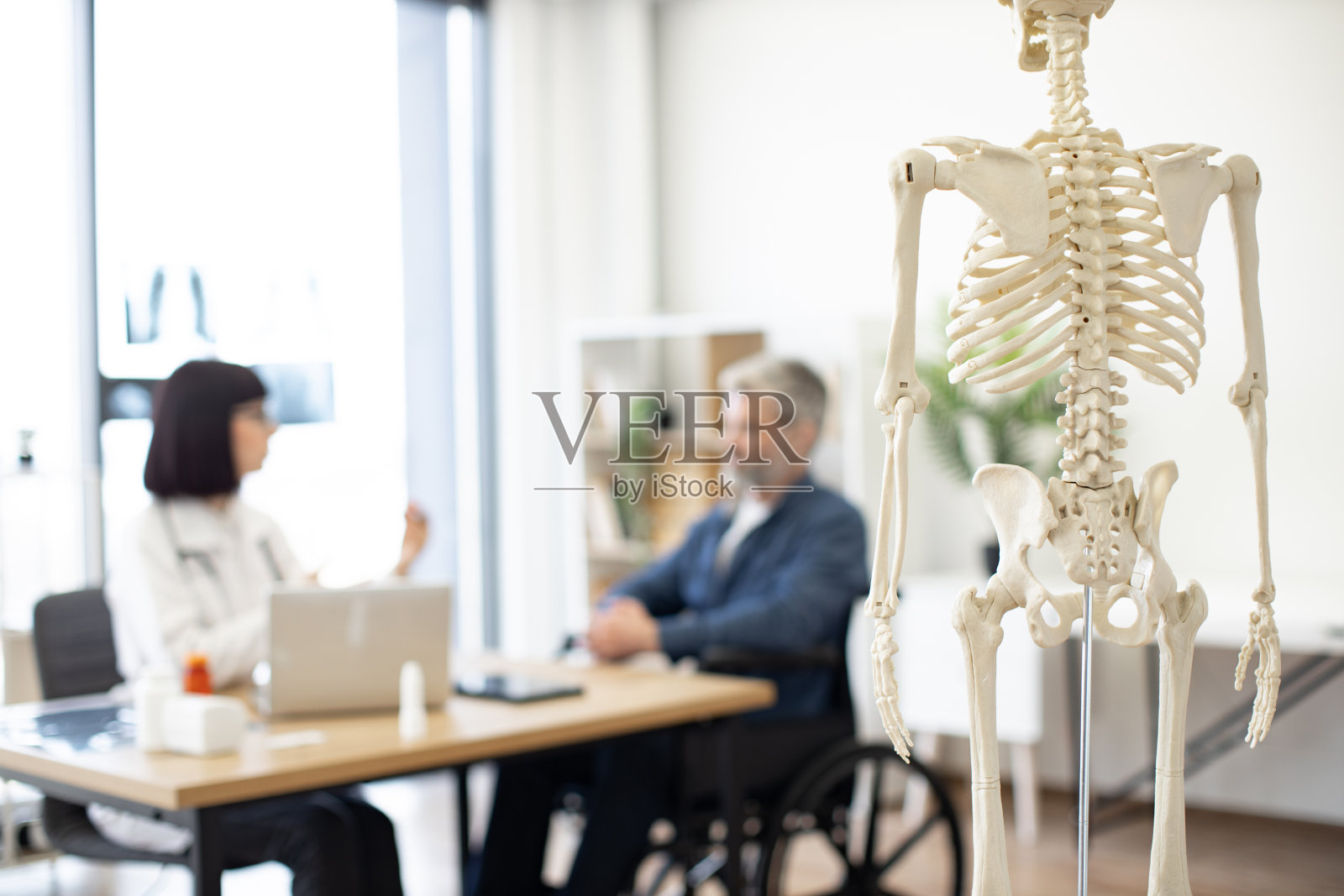 病人检查时医生办公室里的骨骼模型照片摄影图片