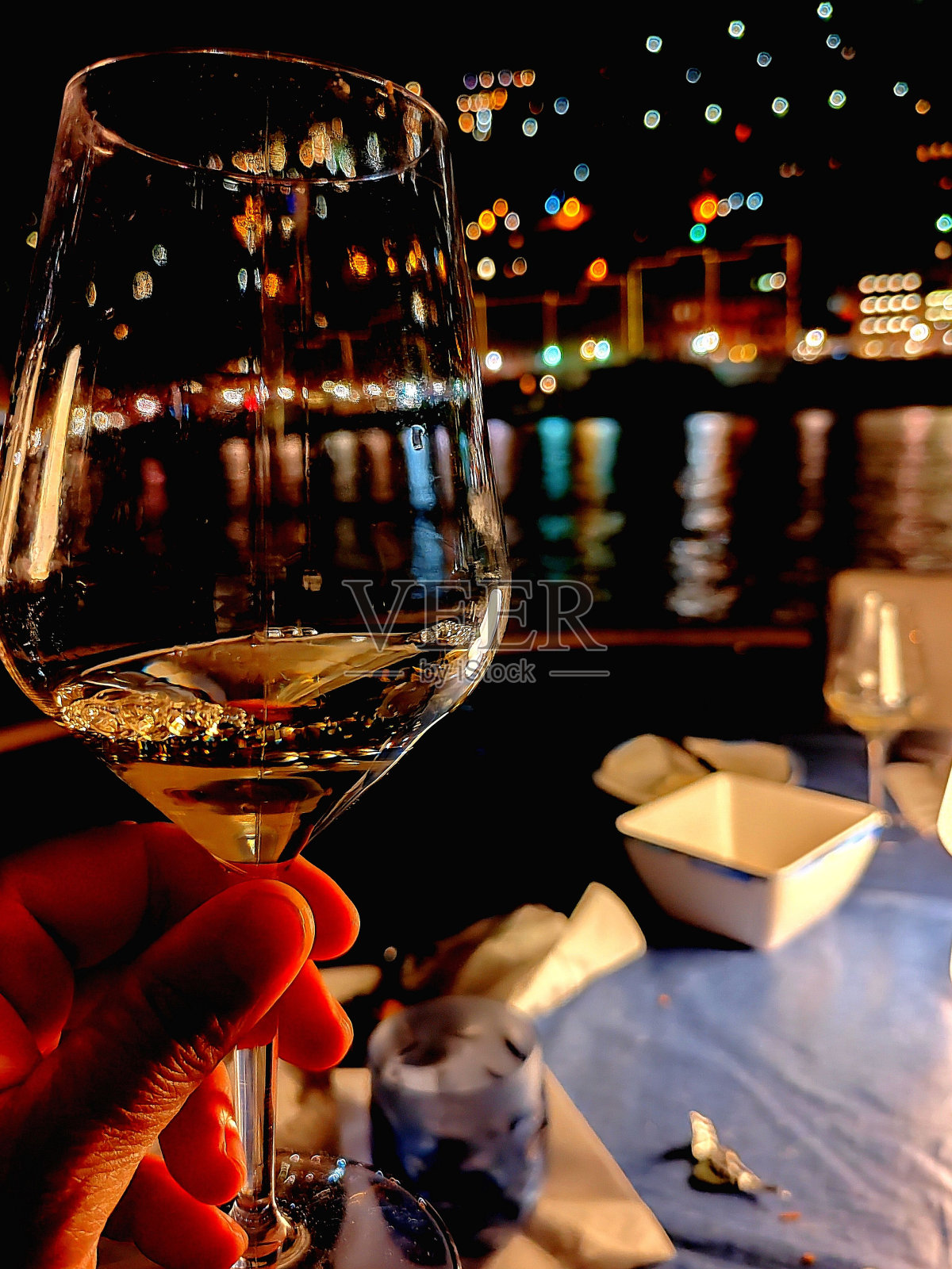 年轻人在一家能看到海滨美景的餐厅里喝着葡萄酒照片摄影图片