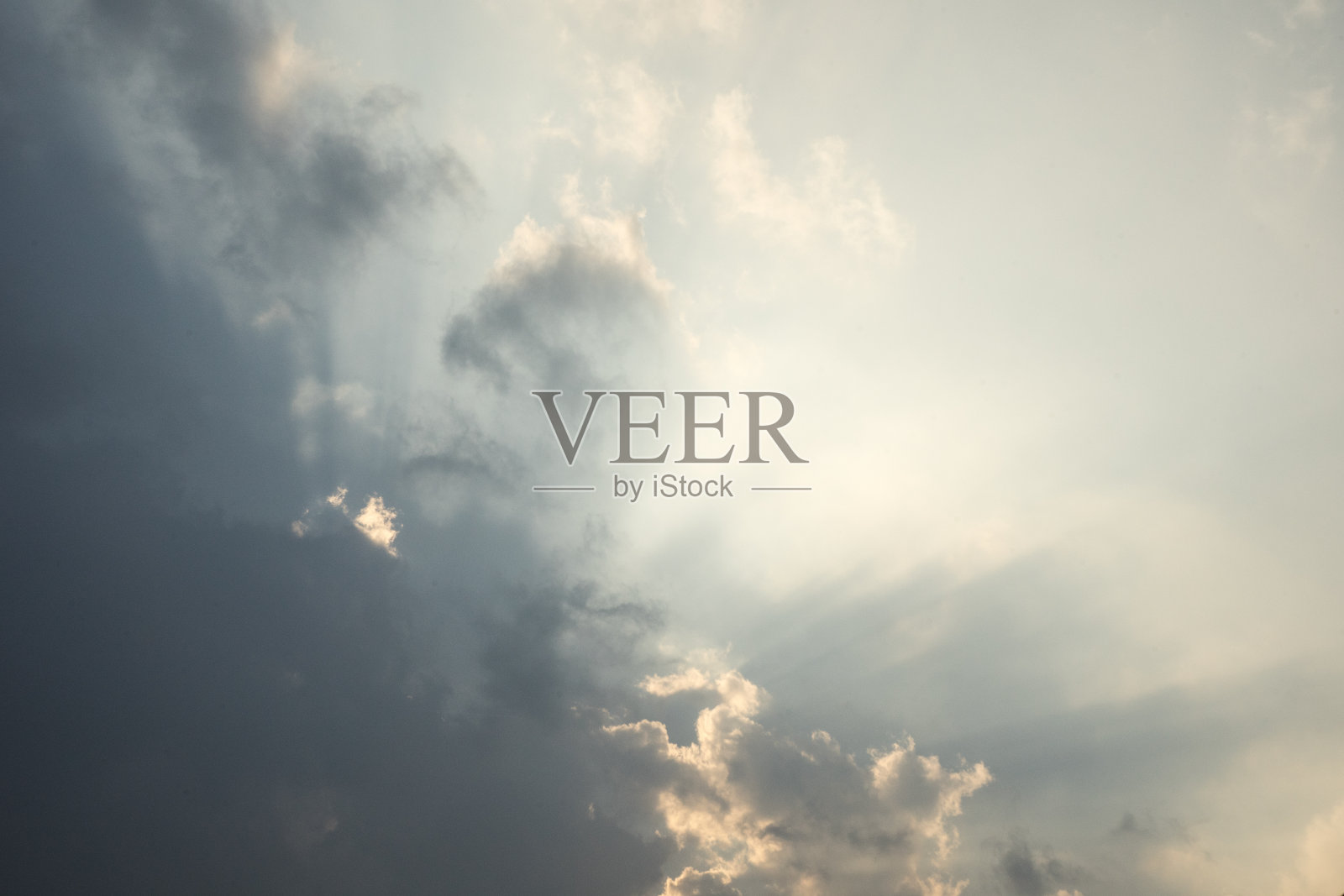 灰色的天空，太阳躲在白云里照片摄影图片