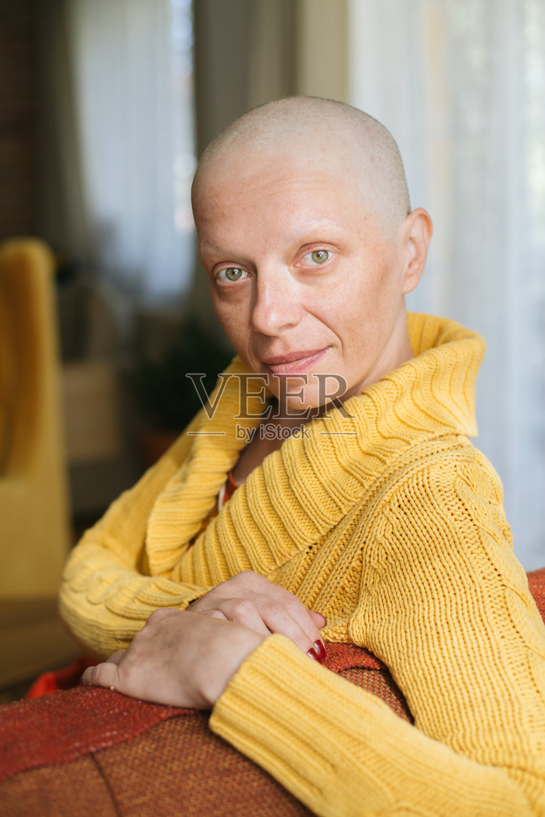 忧心忡忡的年轻癌症幸存者坐在沙发上照片摄影图片