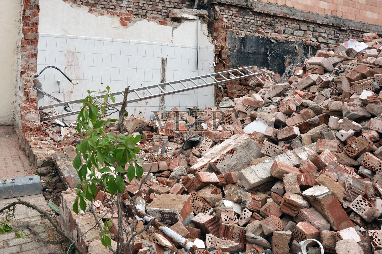 一幢被地震破坏的居民楼的废墟，墙壁破碎，许多砖碎片和楼梯照片摄影图片