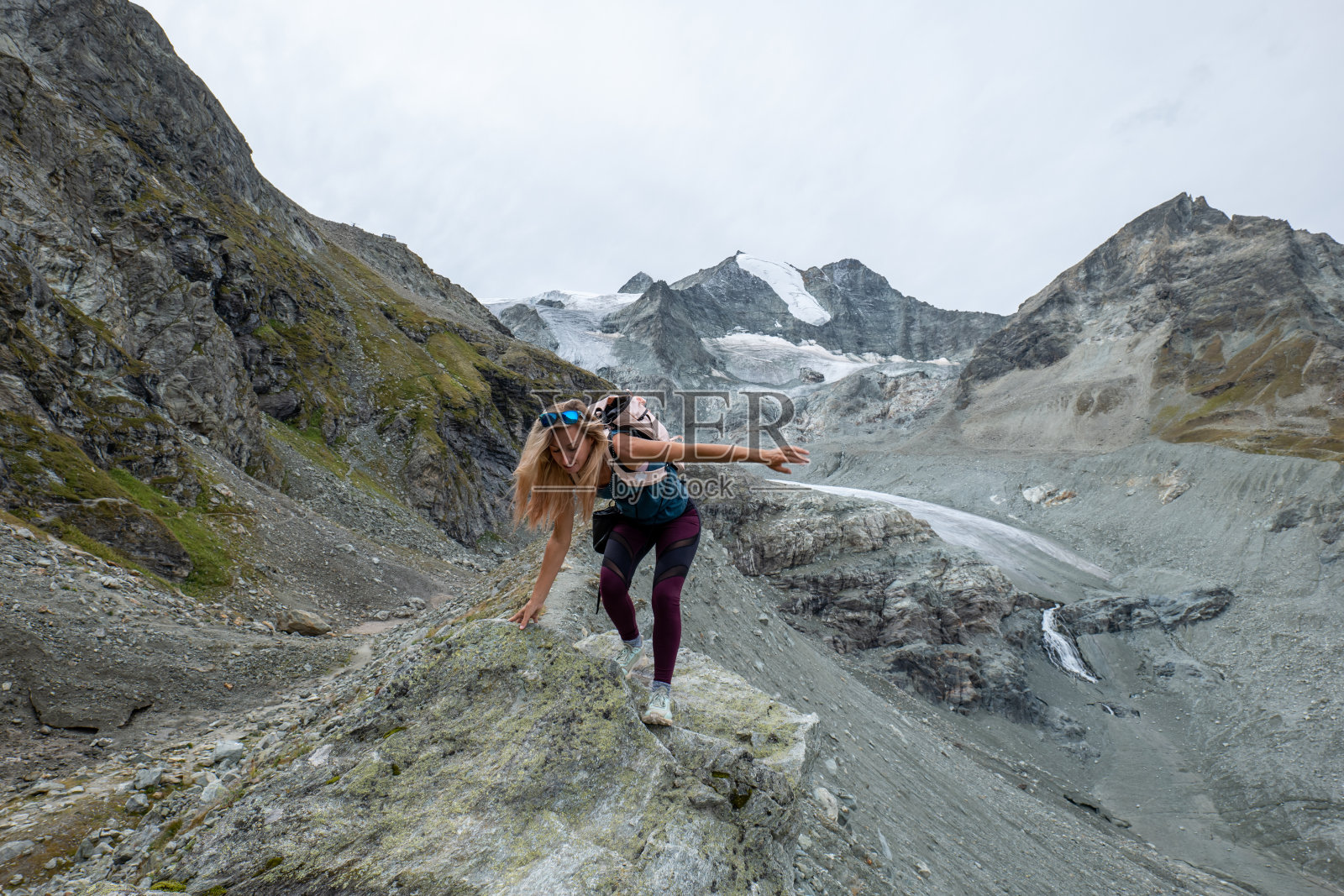 在山脊上徒步的运动女性，她保持平衡照片摄影图片