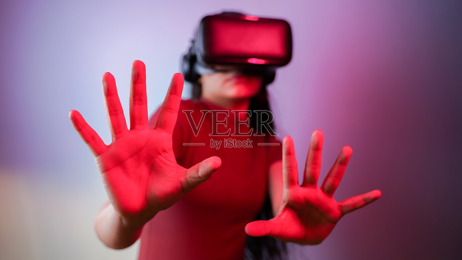 年轻的亚裔印度女子吓坏了，戴着虚拟现实耳机，惊恐的女孩戴着VR眼镜概念工作室肖像照片摄影图片