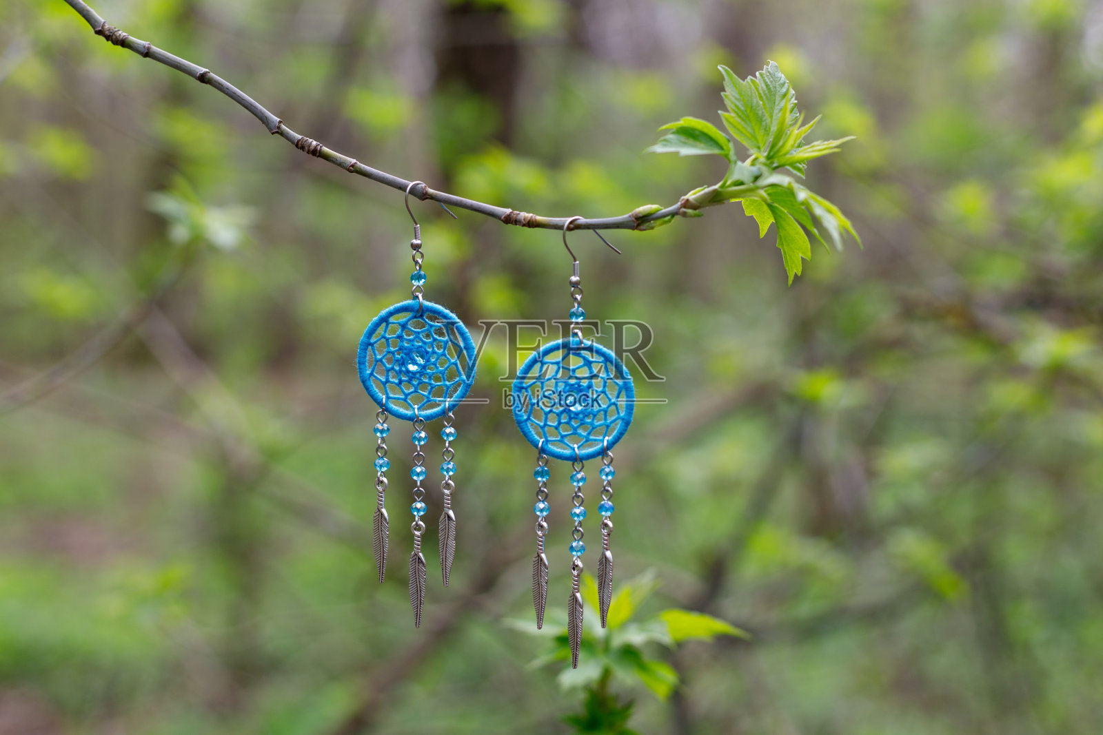 手工捕梦网耳环，用羽毛线和珠子绳挂照片摄影图片