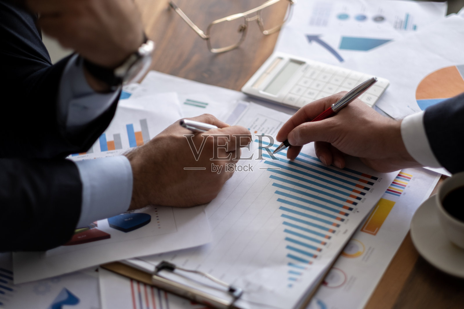 商务会计概念，商务人士使用计算器和笔记本电脑，预算和贷款文件在办公室。照片摄影图片