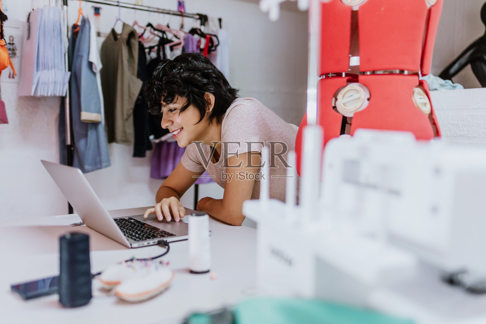 拉丁美洲年轻女性时装设计师在墨西哥纺织创意工坊或笔记本电脑上工作拉丁美洲，西班牙裔小企业主女性照片摄影图片