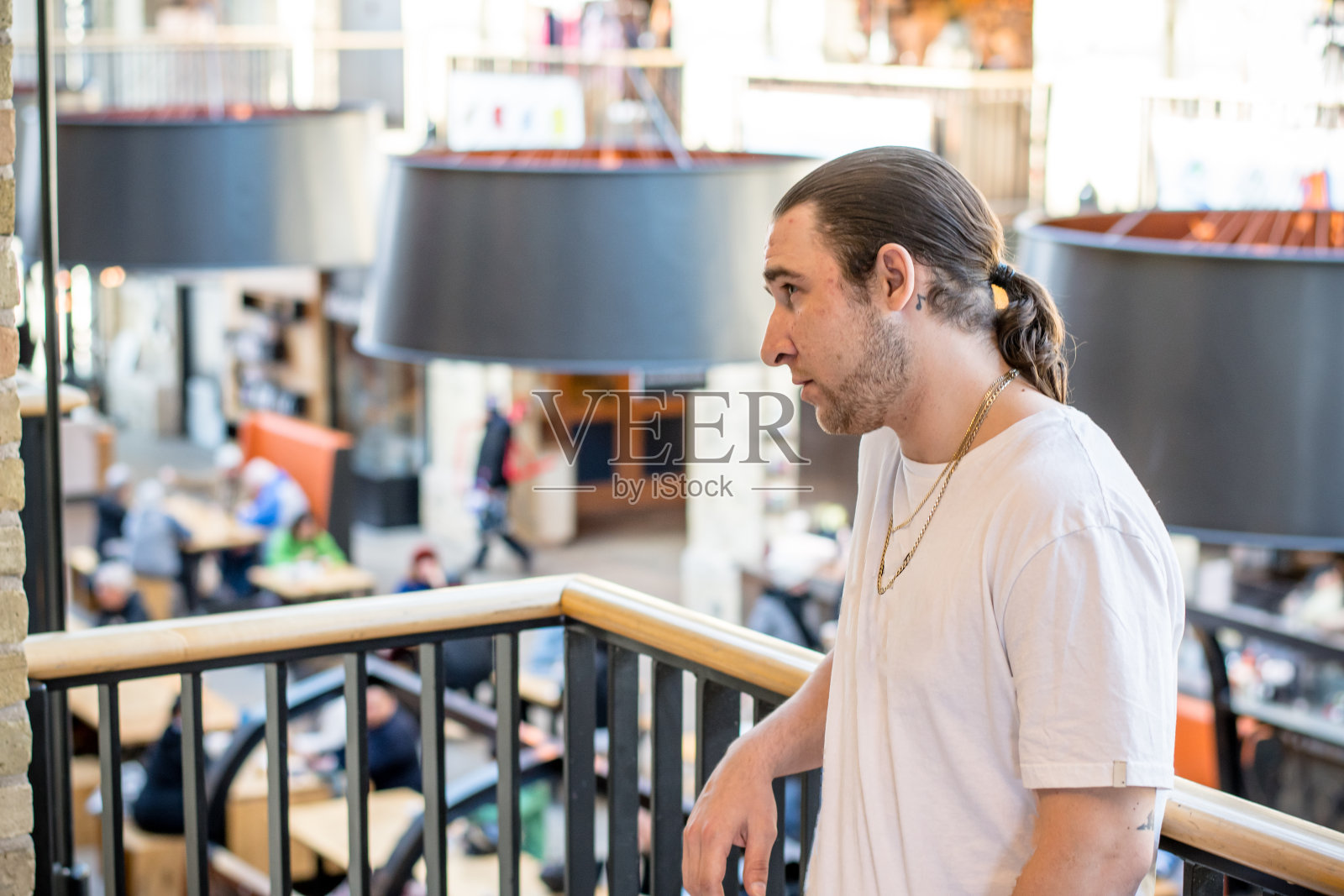 都市的昂首阔步和风格:嘻哈艺术家迷人的白色t恤和珠宝照片摄影图片