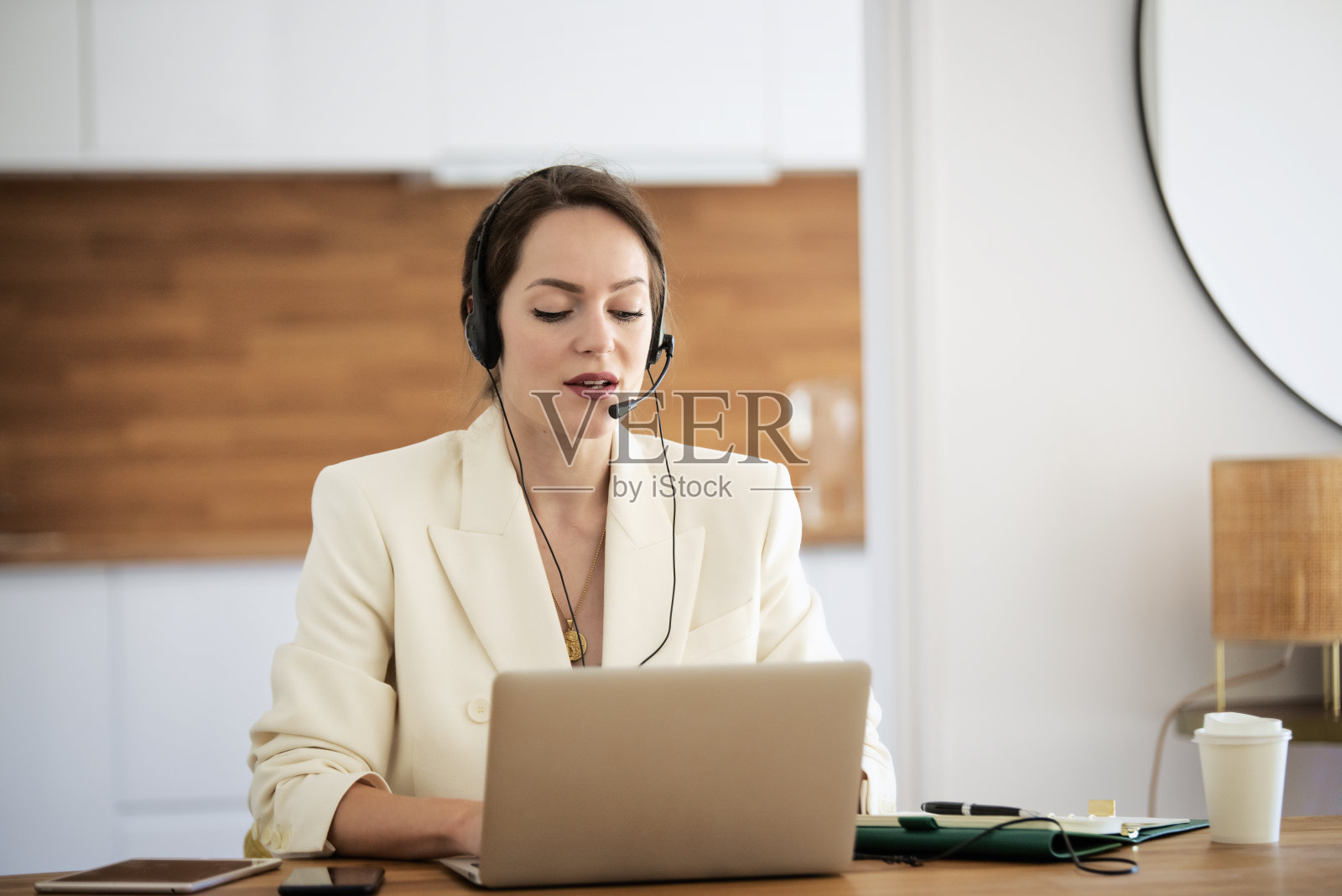 带着耳机和笔记本电脑在家工作的自信女人照片摄影图片