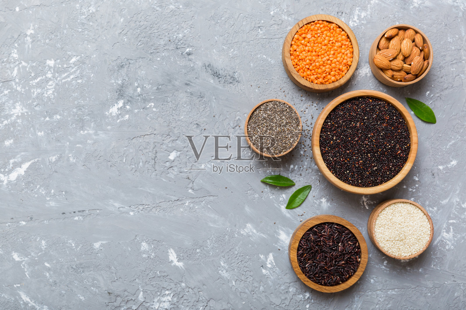 各种超级食物在彩色背景的小碗里。超级食物如大米，奇亚，藜麦，扁豆，坚果，芝麻，杏仁。俯视图复制空间照片摄影图片