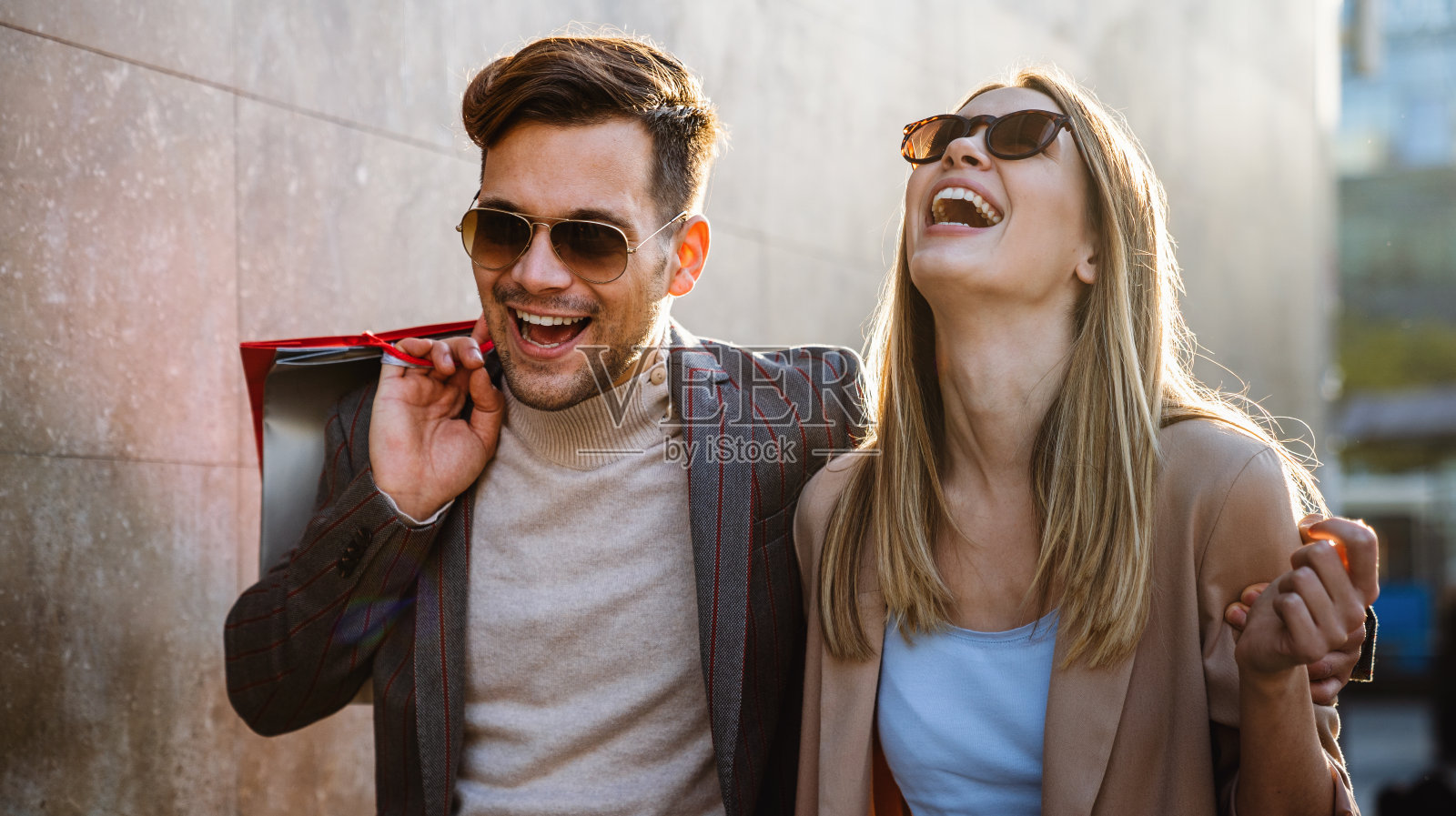 漂亮的年轻情侣提着购物袋，一起享受时光。照片摄影图片