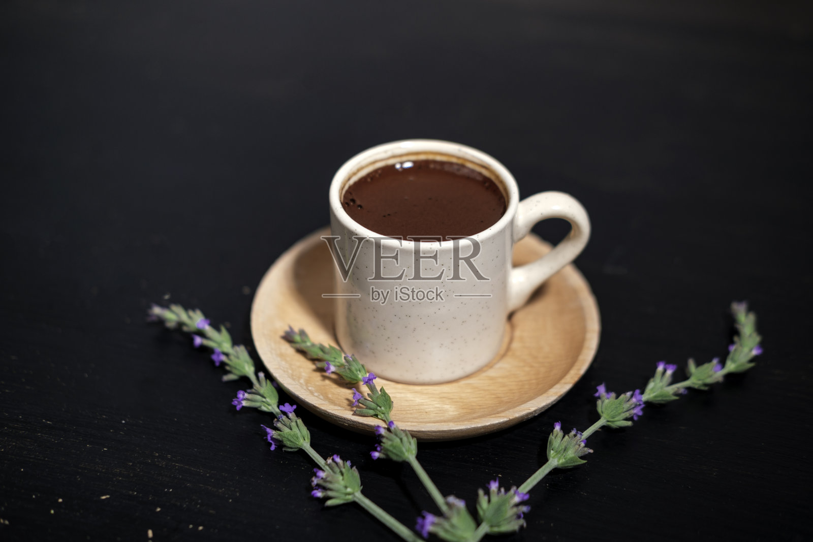 土耳其咖啡黑色背景，白色瓷杯，木制盘子，传统的当地清凉饮料，薰衣草花照片摄影图片